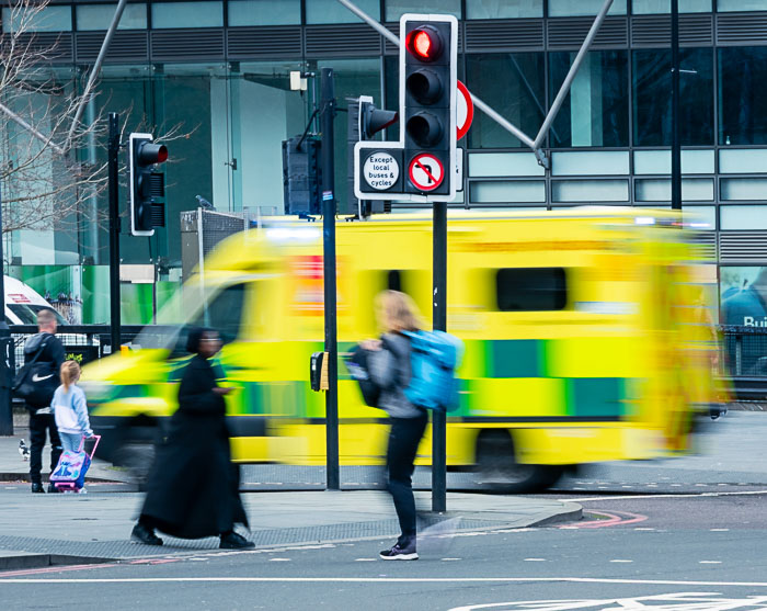 An ambulance speeding through a city centre
