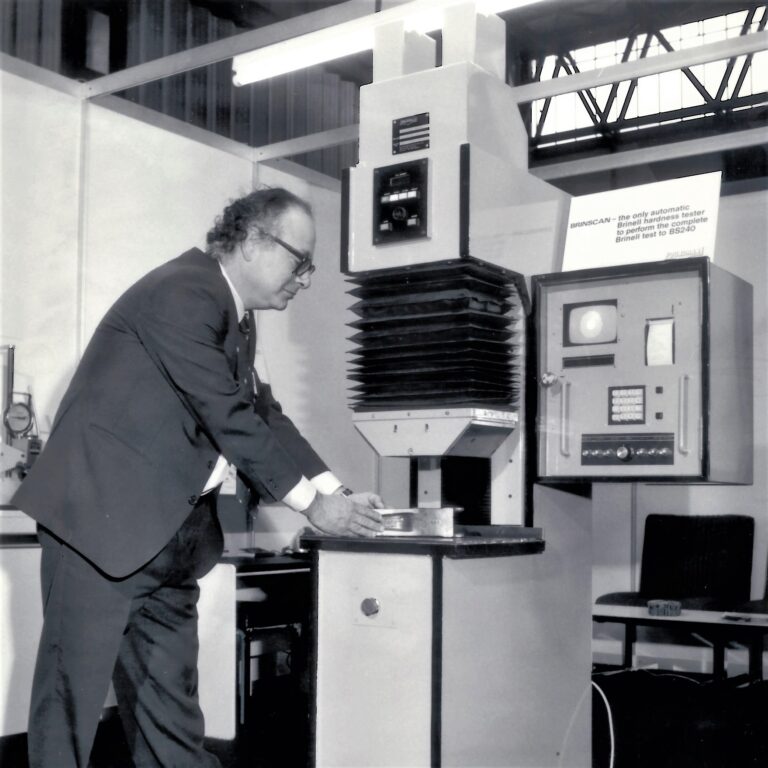 The World's first commercially available, fully-automatic Brinell hardness testing machine, photographes at a trade expo in 1983.