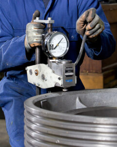 A portable Brinell hardness tester manufactured by Foundrax being used to test a lift cable drum